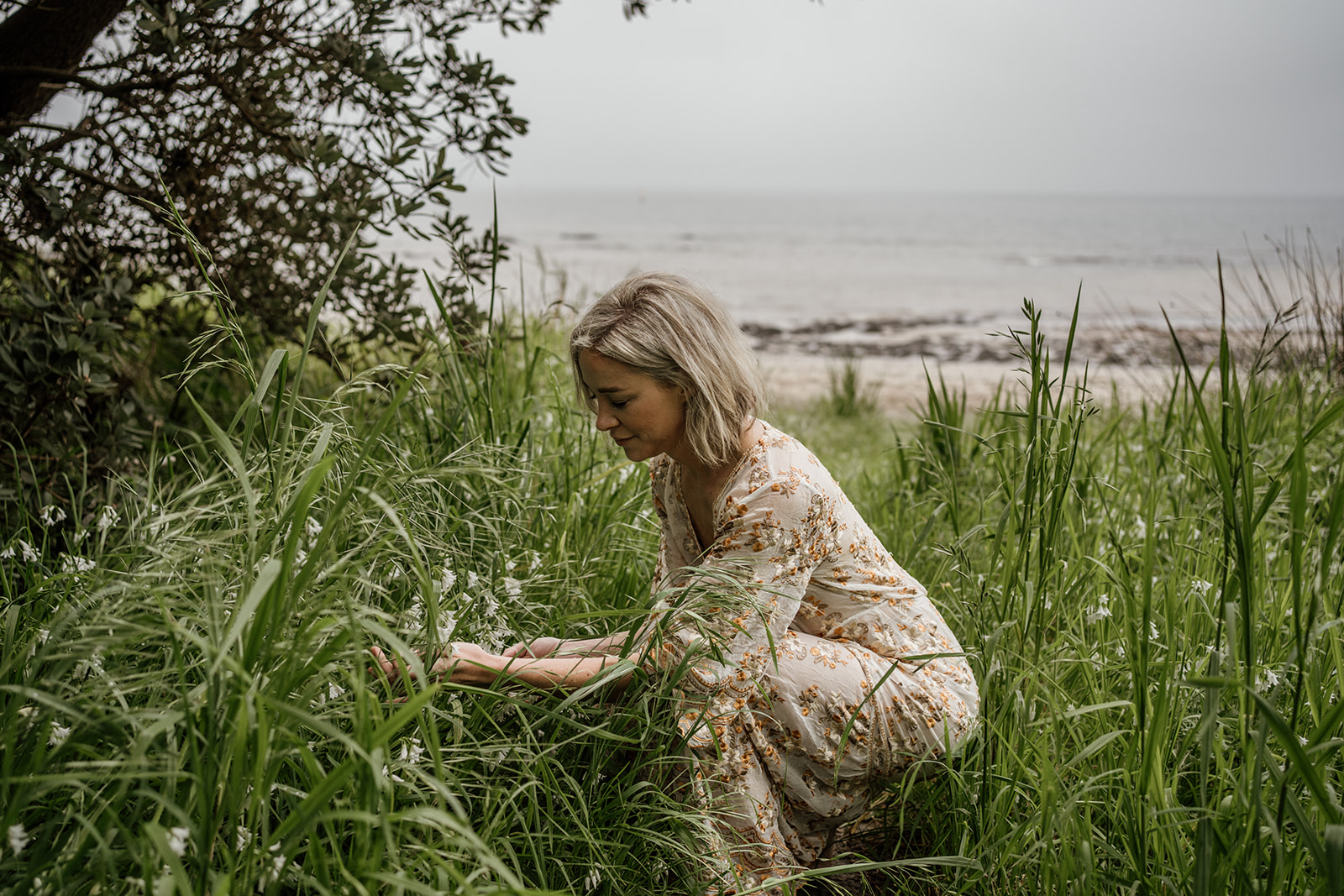 sophie dawn wellness green foraging in a beautiful long dress arnhem by the beach woman in the long grass